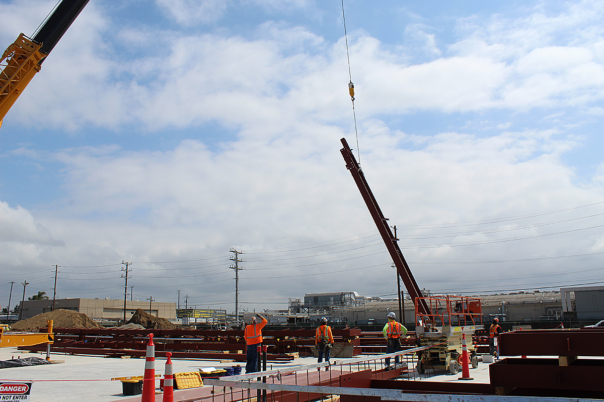 The first steel beam is set at the Maintenance and Storage Facility.