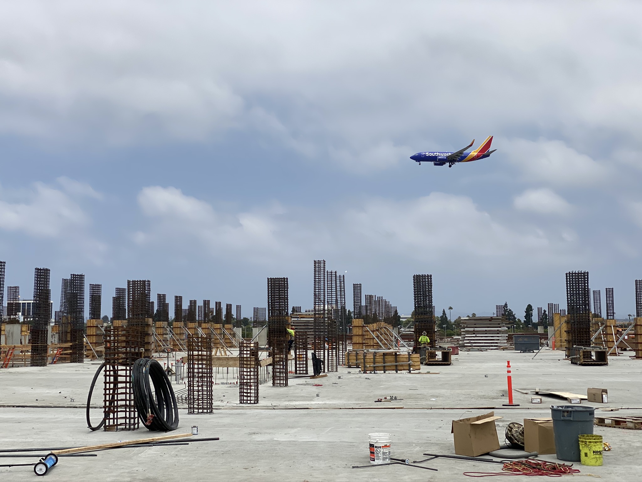 A plane flies over the second level of the Intermodal Transportation Facility-West.