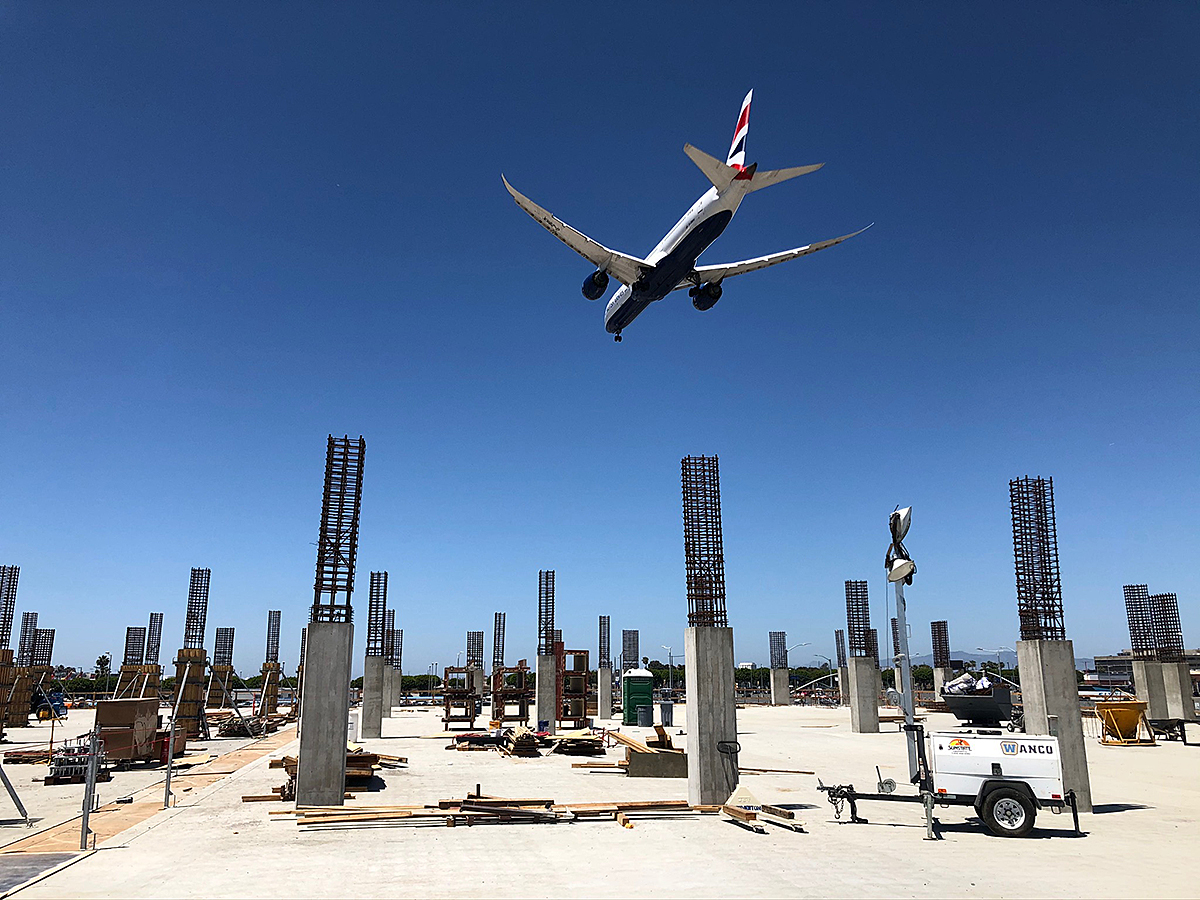 A British Airways plane flies over the second level of the Intermodal Transportation Facility – West