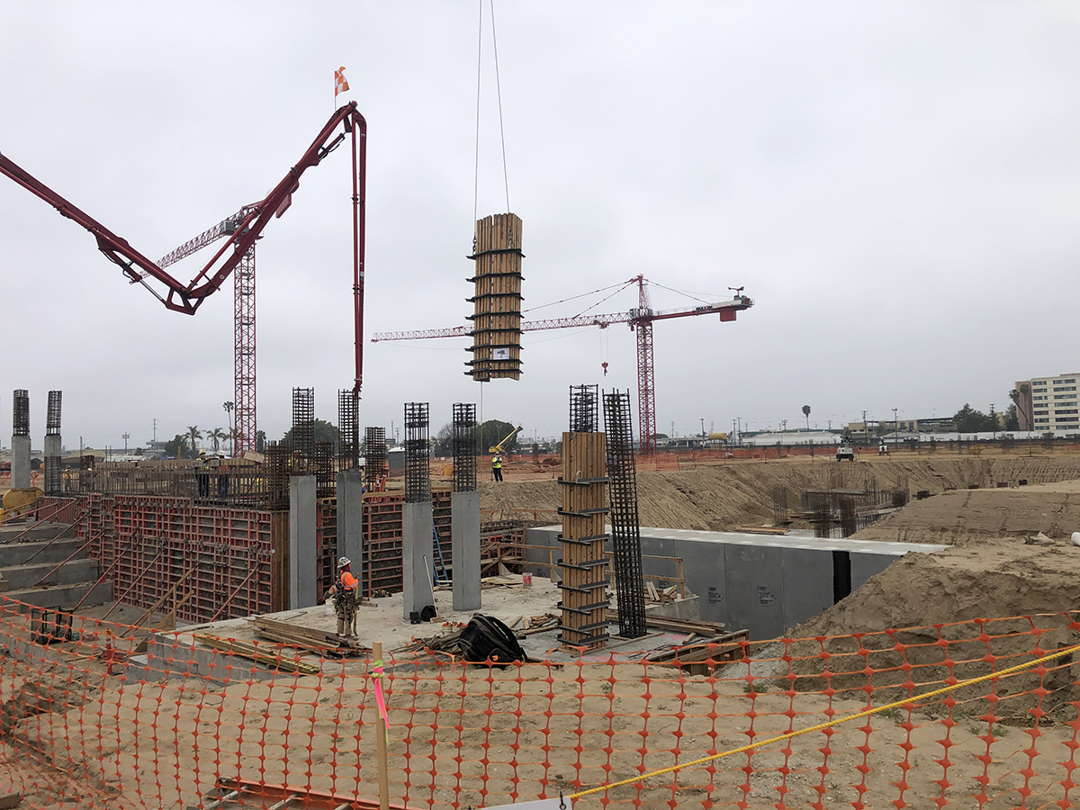 A crane lifting formwork into place at the Consolidated Rent-A-Car facility site.