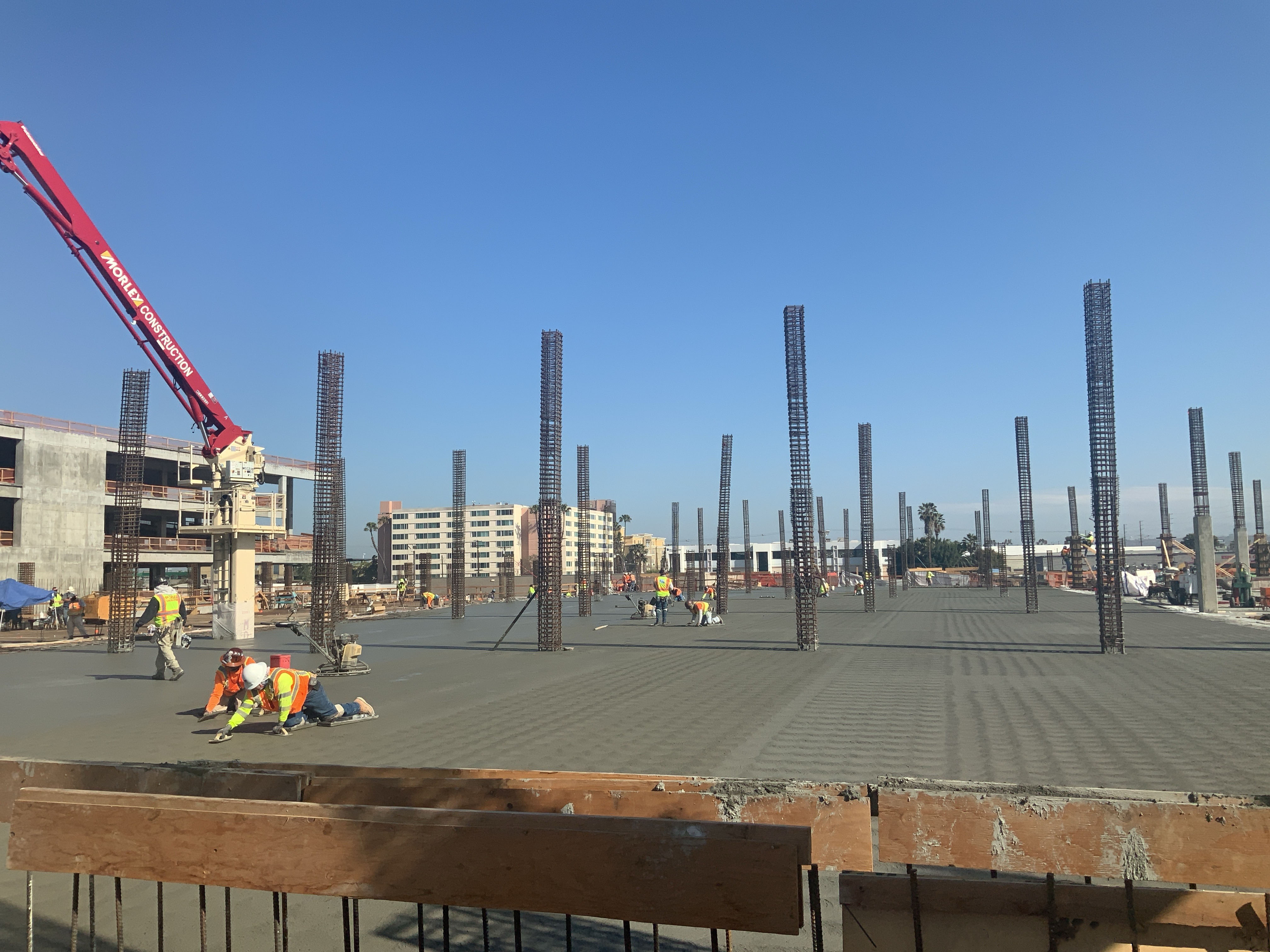 Finishers completing a concrete deck pour on the second level of Consolidated Rent-A-Car facility Idle Storage building.