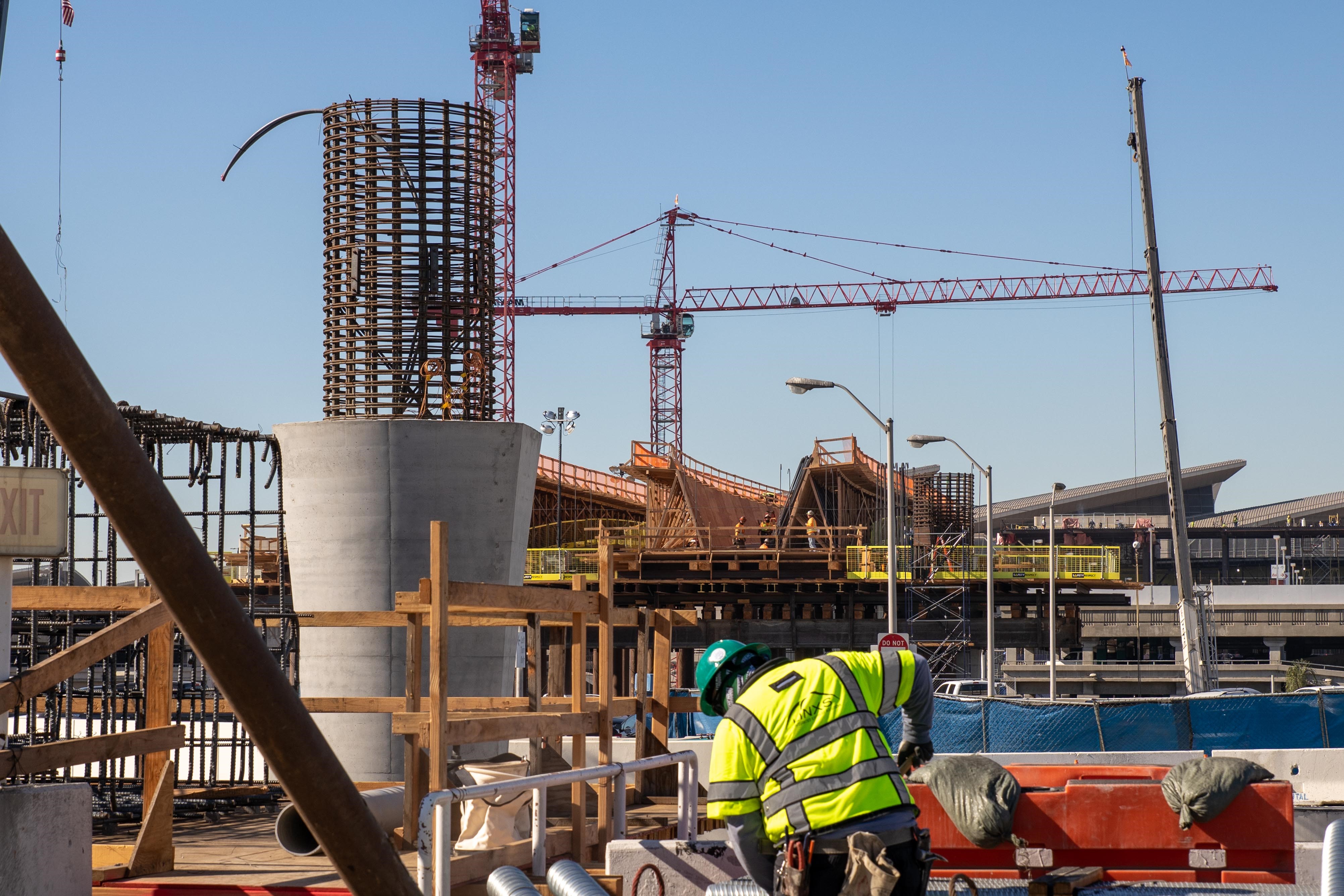 As construction of the APM guideway advances, formwork is constructed atop a falsework platform, into which concrete will eventually be placed.