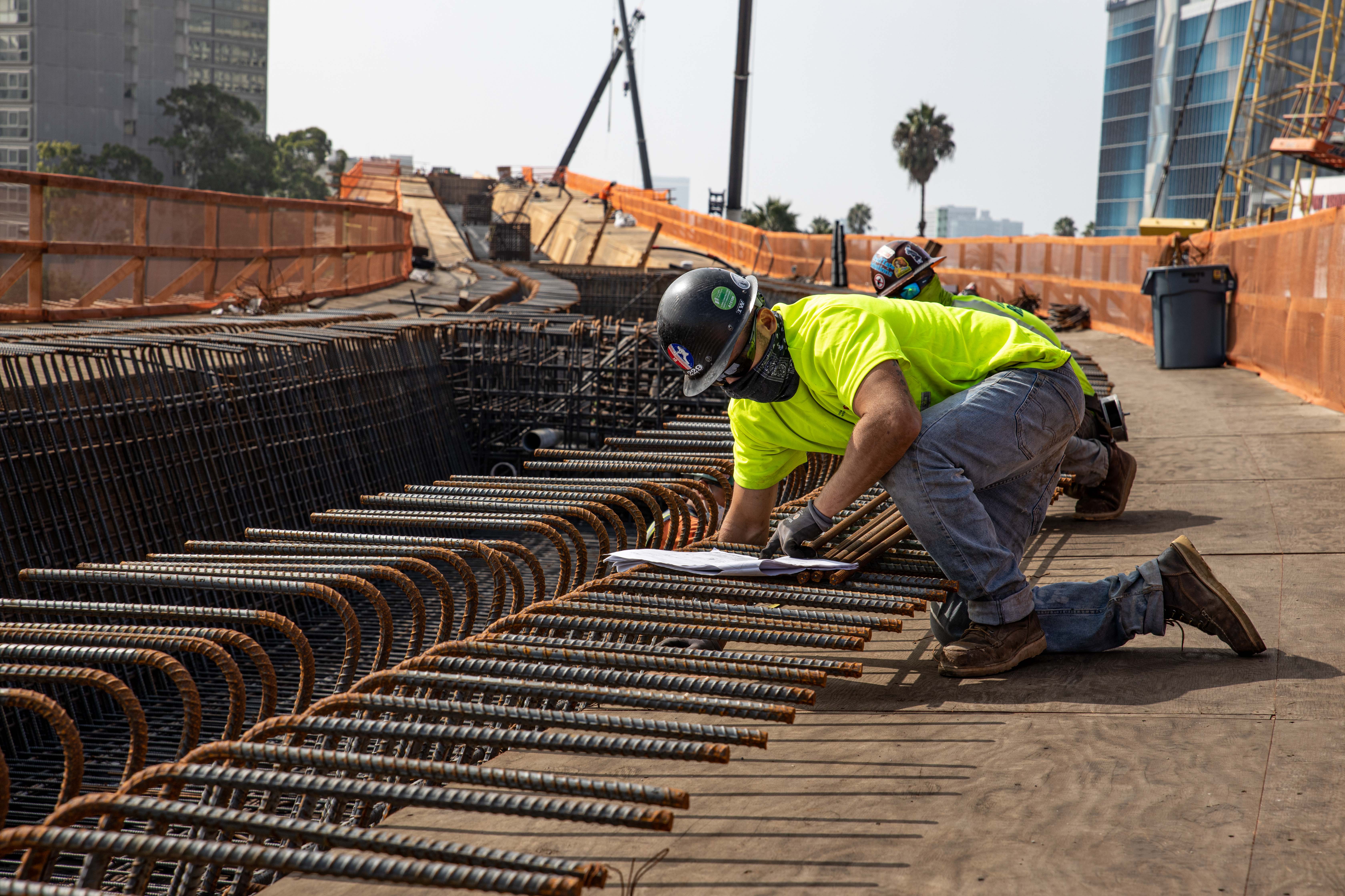 Workers verify correct placement of the guideway reinforcement bar.