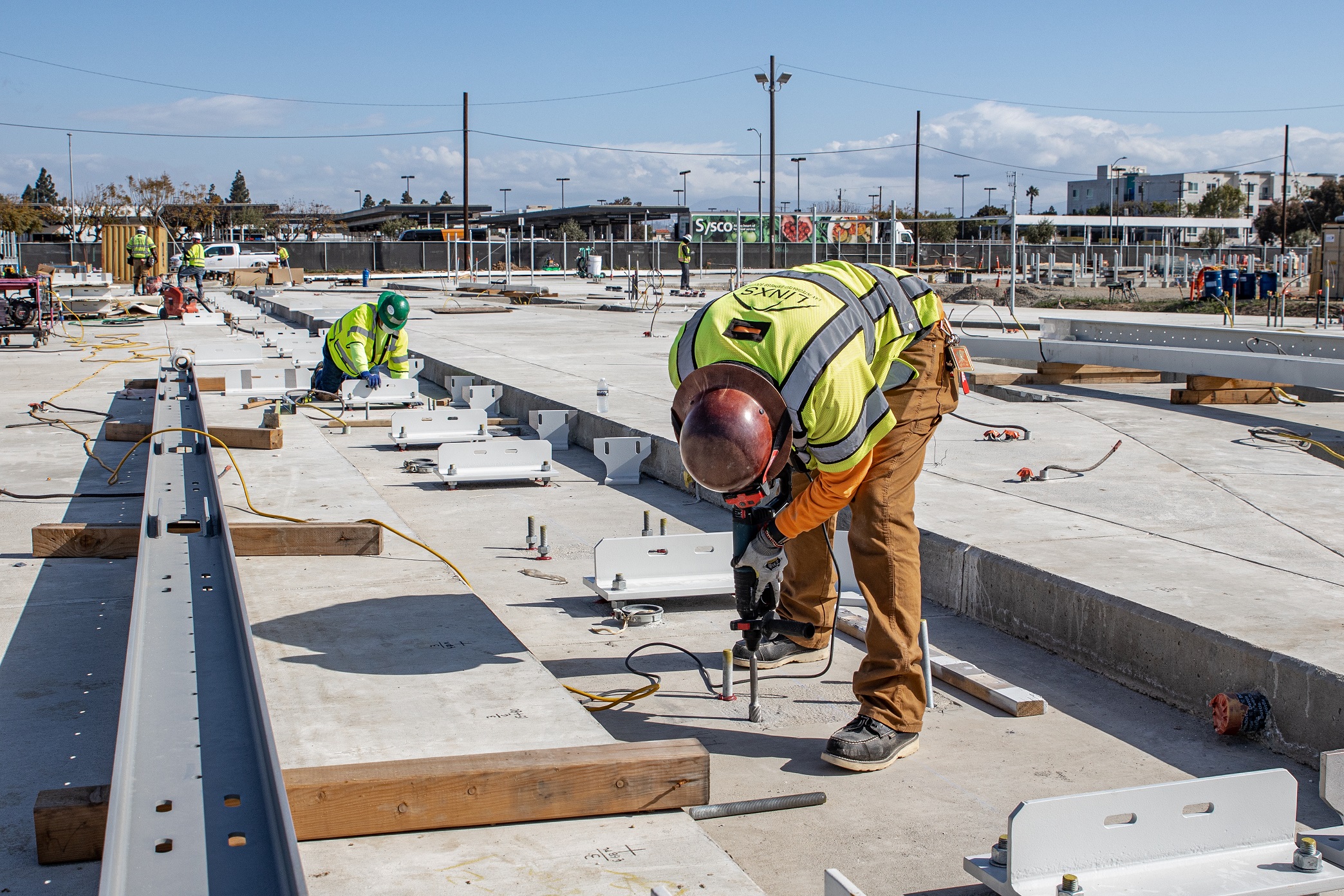 Crews work to install guidebeams and pivot switches for the test tracks servicing the Automated People Mover system's future Maintenance and Storage facility.