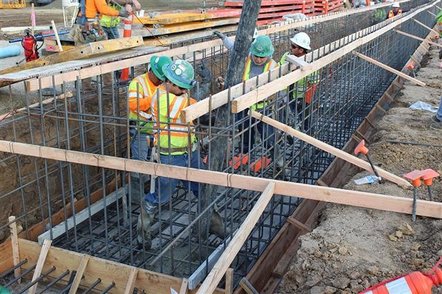 Construction workers piped in the first concrete for the foundation of the Automated People Mover Maintenance and Storage Facility.