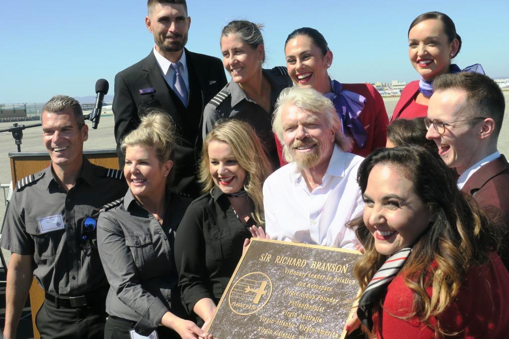 Richard Branson poses for a picture with employees of Virgin Group's airlines